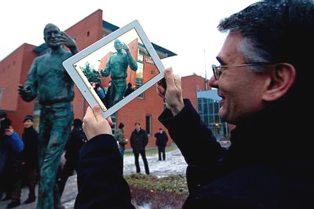 Мужчина фотографирует на iPad памятник Стиву Джобсу в Будапеште