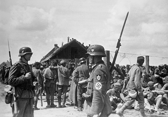 Немецкие солдаты конвоируют советских военнопленных, пленённых после сражения под Уманью, 1941 год