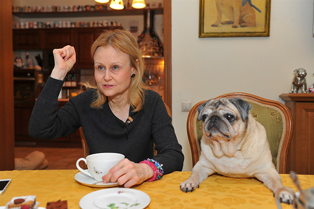 Дарья Донцова с собакой за столом у себя дома